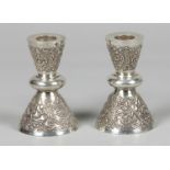 A set of silver candlesticks with a Buddhist image, marked