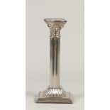 A silver-plated candlestick in the shape of a Corinthian co