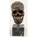A bronze carved skull on a marble base. 2nd half of the 20t