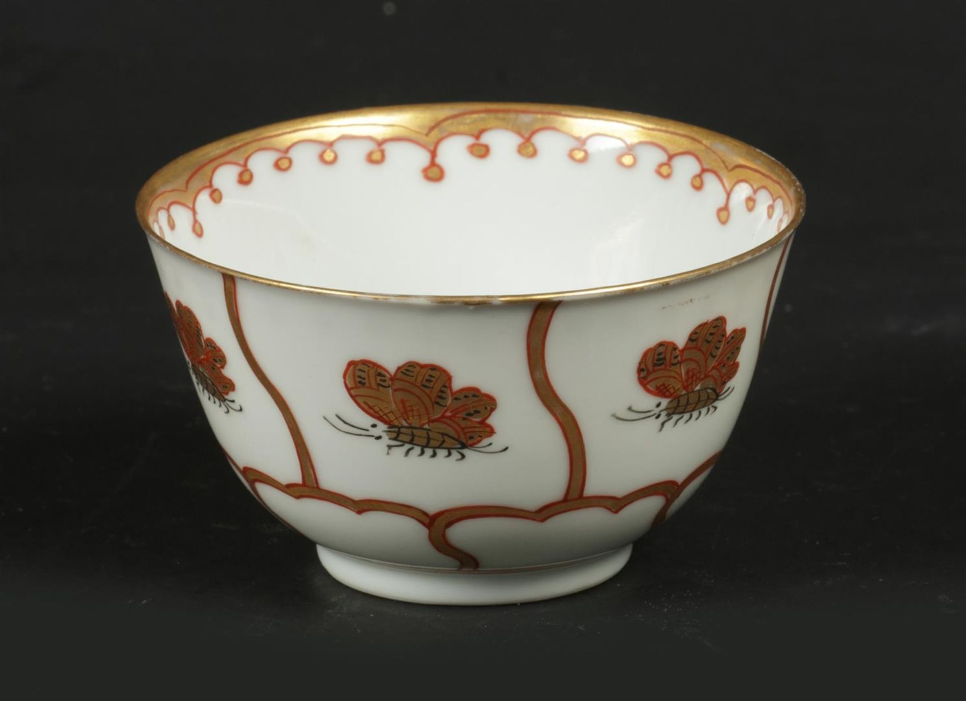 A porcelain cup with a gilded flowerbed decoration with but