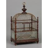 A birdcage with copper bars, porcelain drinking bowls and e