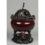 A monochrome sang de boeuf incense burner on a wooden base