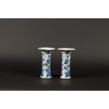 A pair of porcelain beaker vases with floral decor on rock