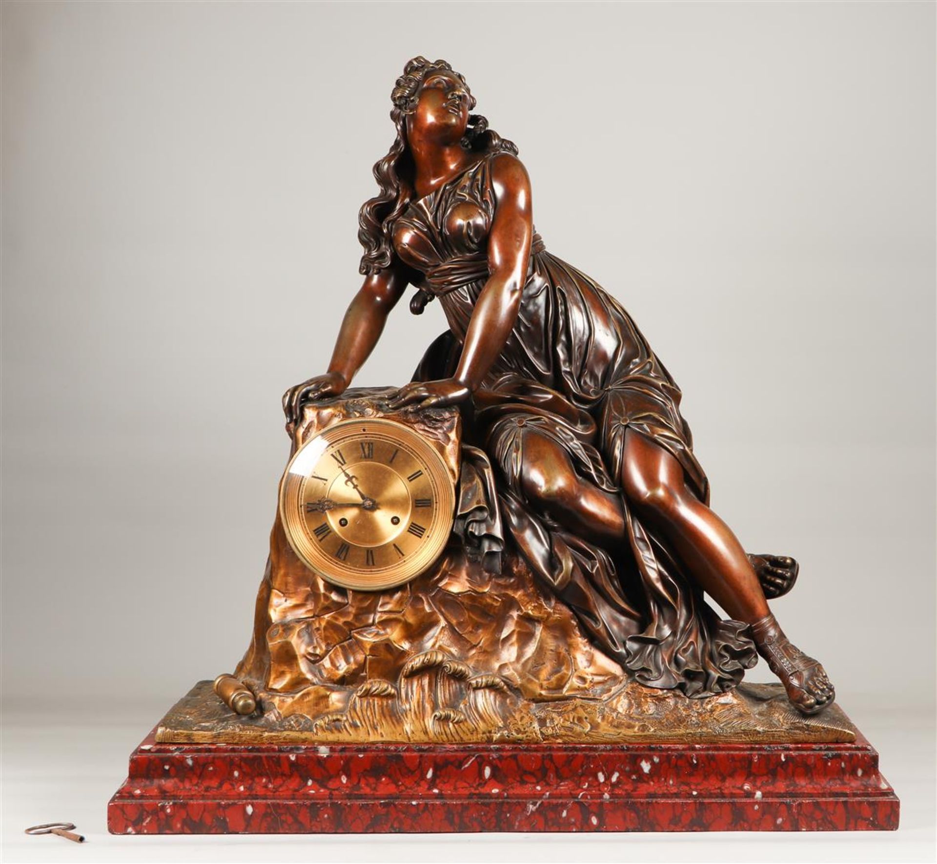 A large mantel clock in a bronze case depicting a young bea
