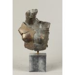 A partly patinated bronze female torso on a hard stone base