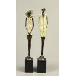 Two bronze statues depicting a man with a hat and an elegan