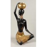 A bronze partly patinated statue depicting an African lady.