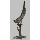 A large bronze sculpture (life-size) of a gray parrot, sitt