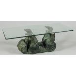 A bronze sculpture of a lying bear cub with hard glass top.