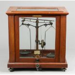 A pharmacy scale in a wooden display case. F.E. Beckers & C