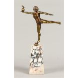 A polished bronze sculpture of a gymnast balancing on a bal