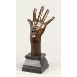 A surrealist bronze of a hand with a face. 2nd half of the