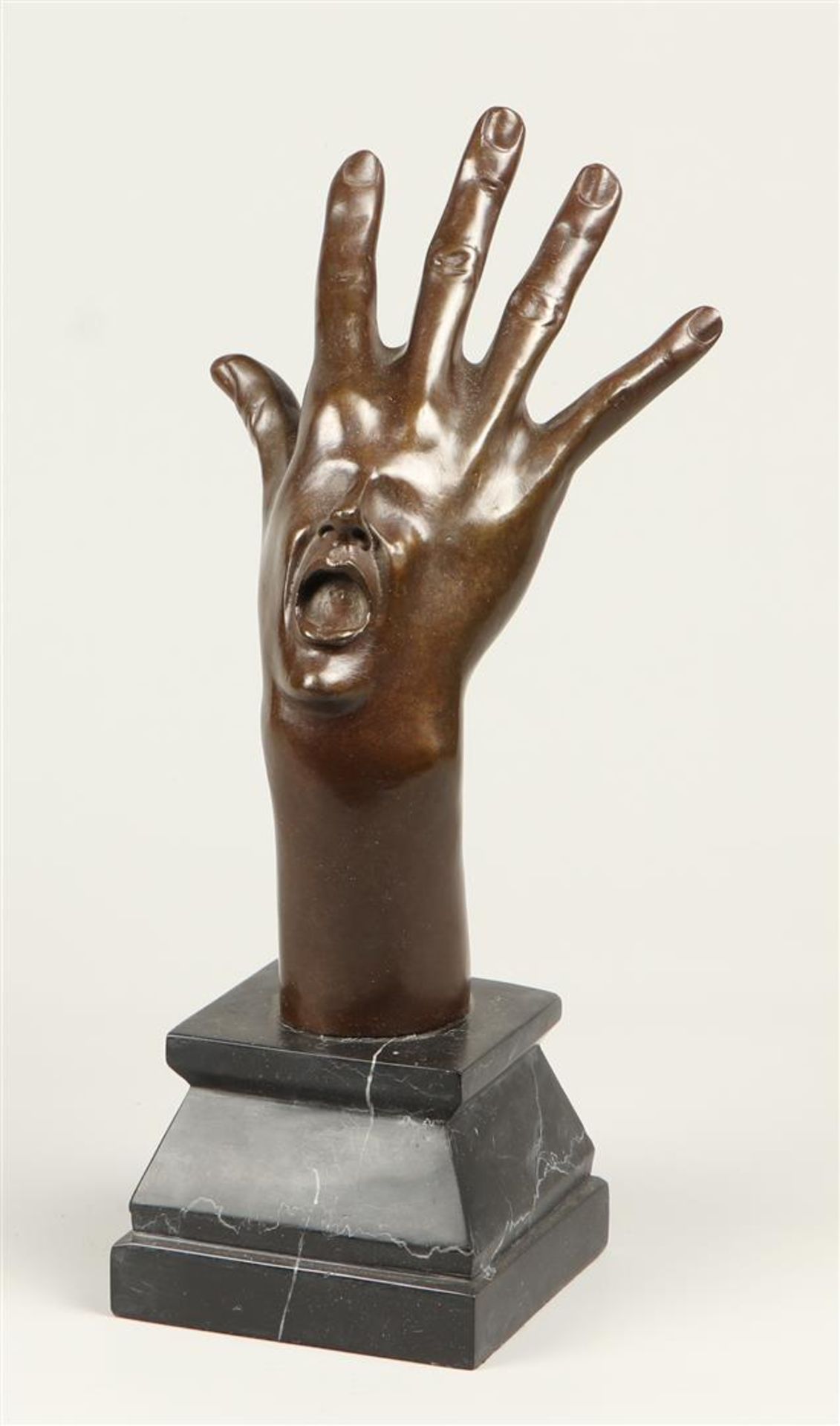 A surrealist bronze of a hand with a face. 2nd half of the 