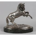 A silver sculpture of a rearing horse on an oval base of gr