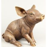 A bronze sculpture depicting a sitting piglet. 2nd half of