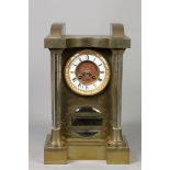 A brass mantel clock with glass columns. Early 20th century