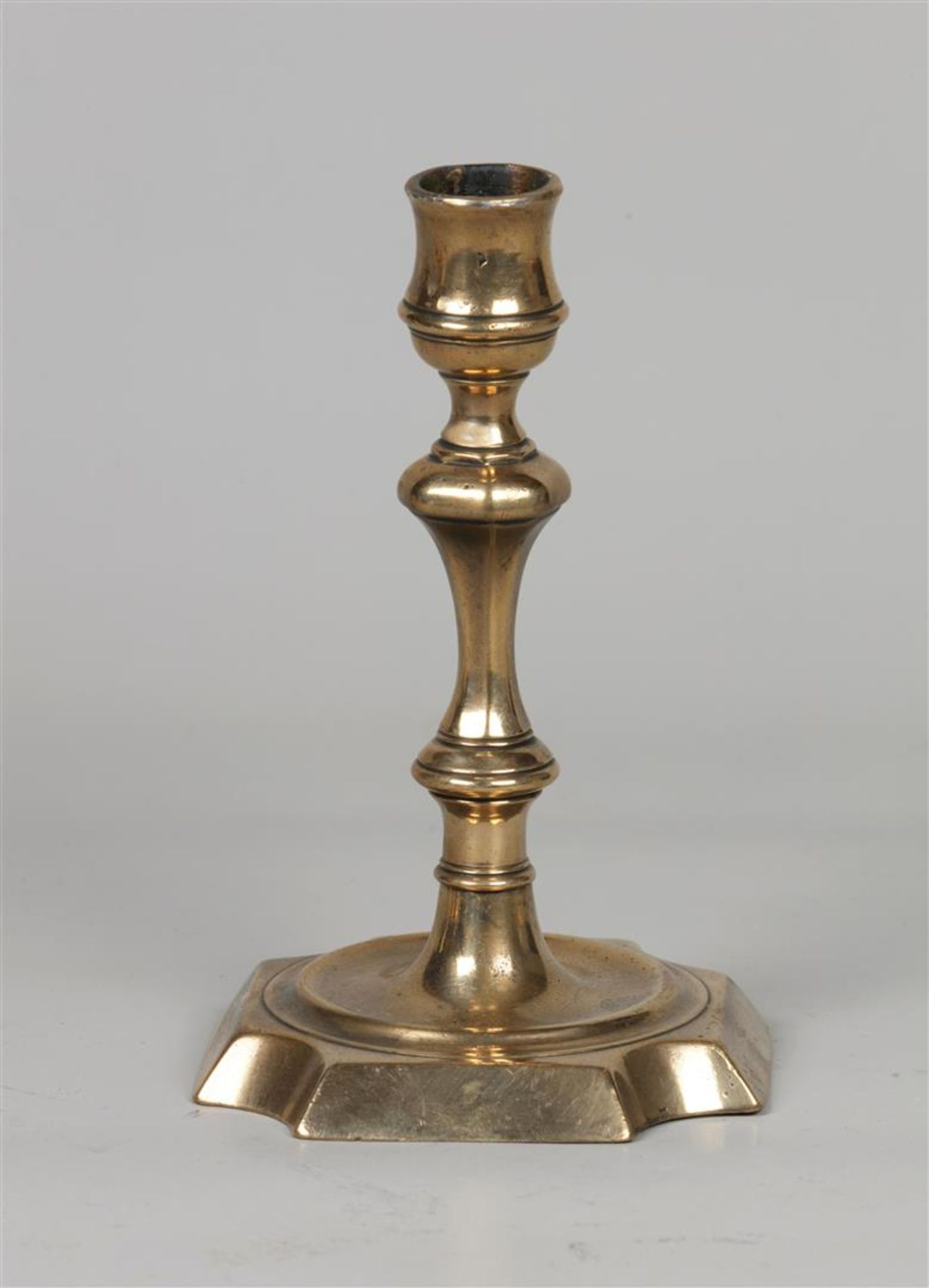 A bronze candlestick. England, 18th century.
H.: 16,5 cm.