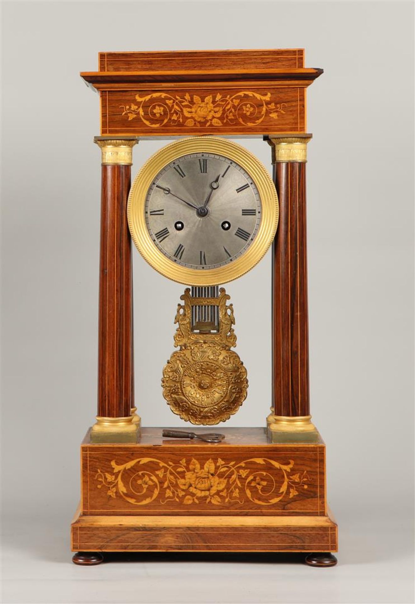 A mahogany column mantel clock with intarsia inlay of fruit