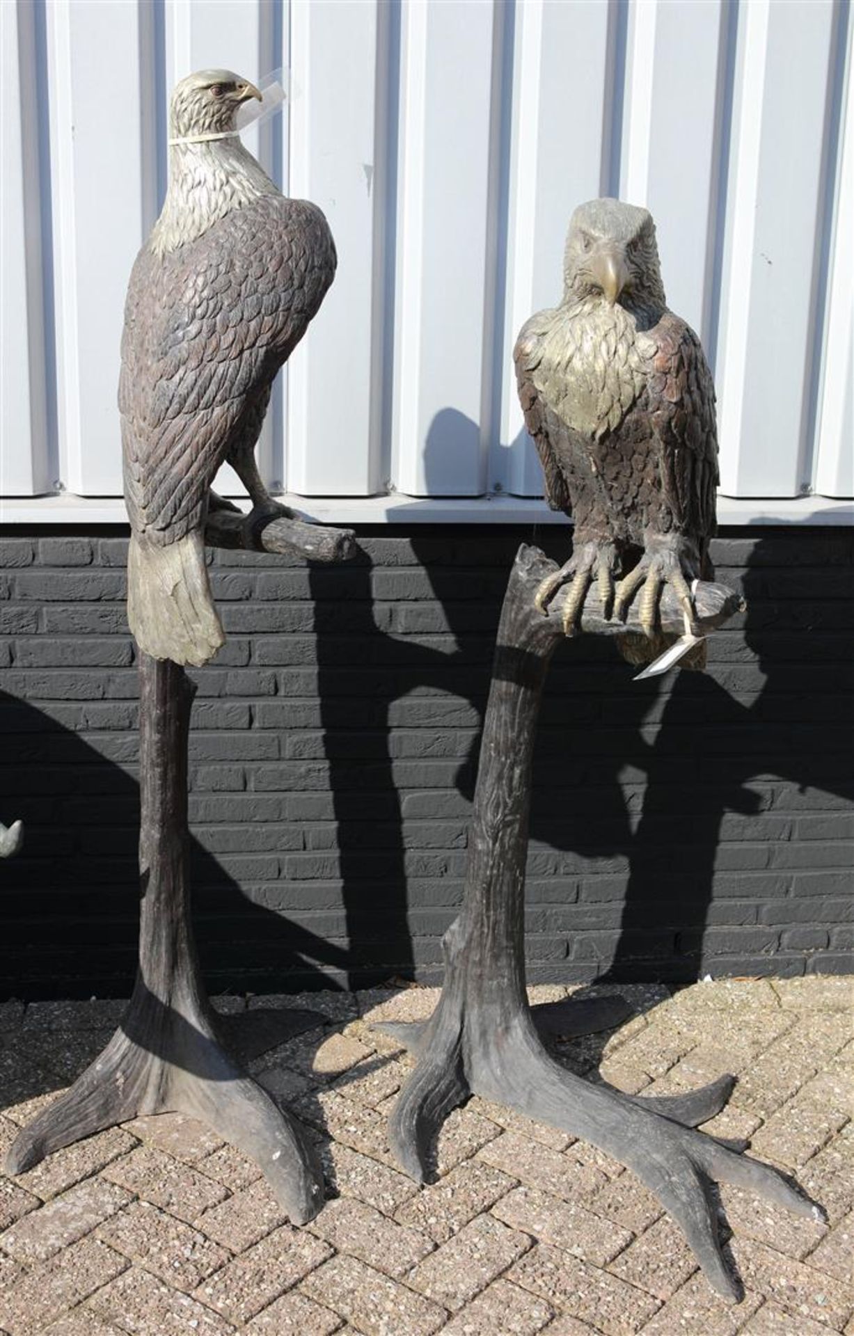 A life size bronze statue of an American eagle on a branch.