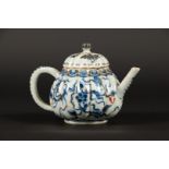 A porcelain ribbed teapot with floral decoration, partly ra