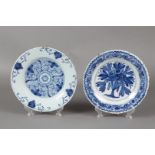 Een lot van twee aardewerk borden met floraal decor. Delft,