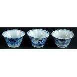 Three porcelain contoured cups and saucers with landscape and willow decor. China, Qianlong.
