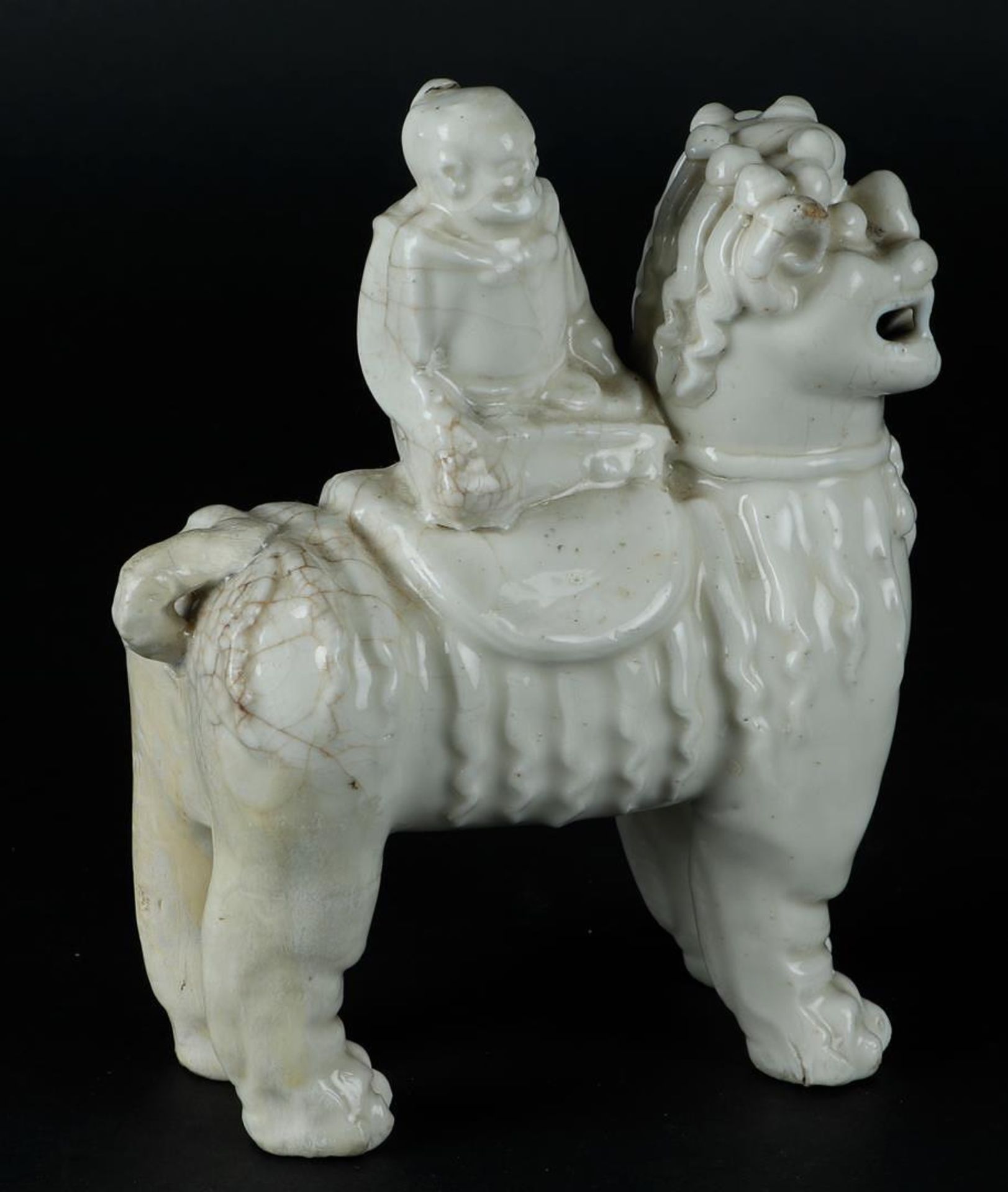A porcelain blanc de chine foo dog with a figure on it. China, Kangxi. - Image 5 of 6