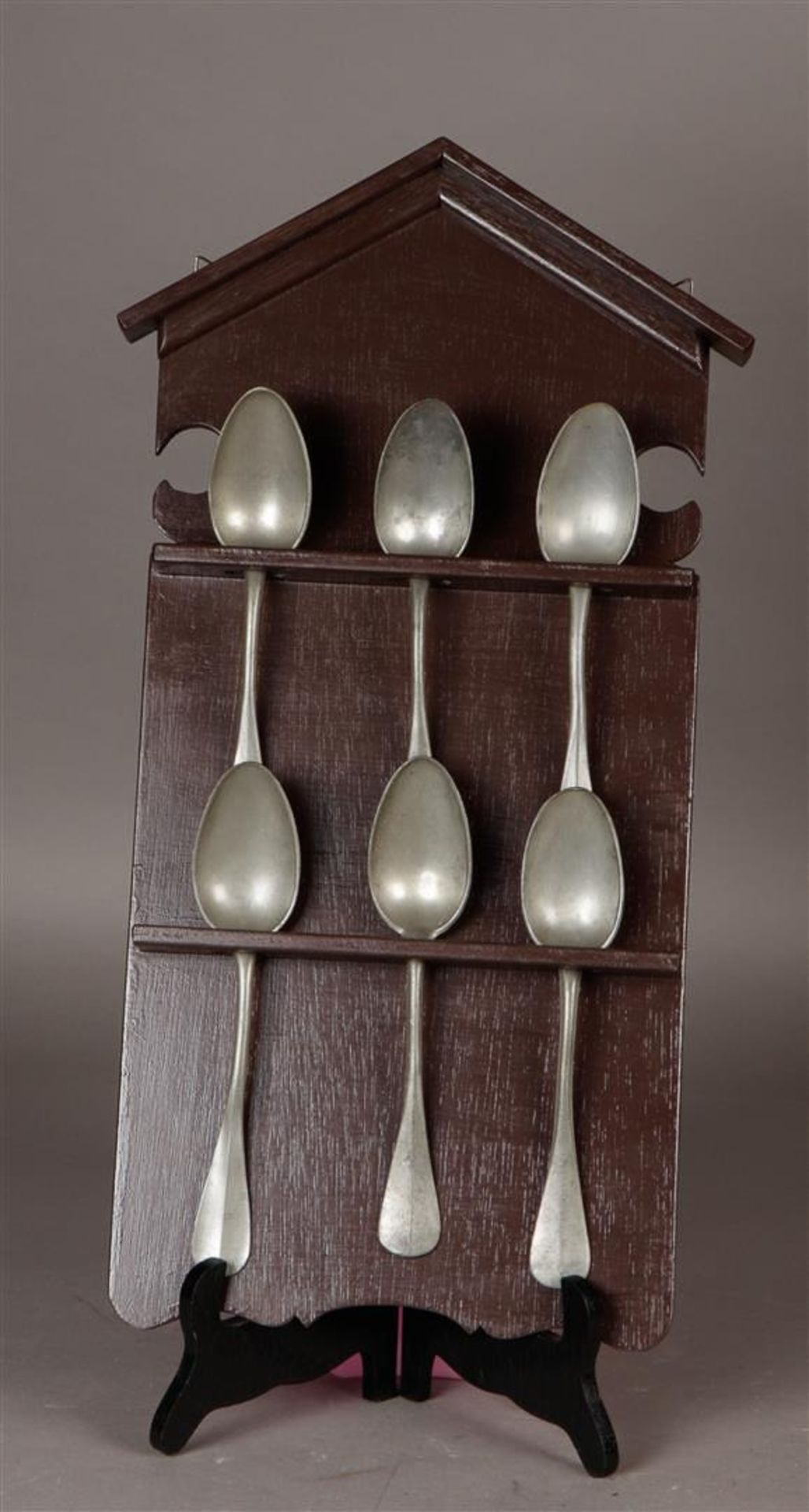 A wooden spoon rack with pewter spoons. 19th century.