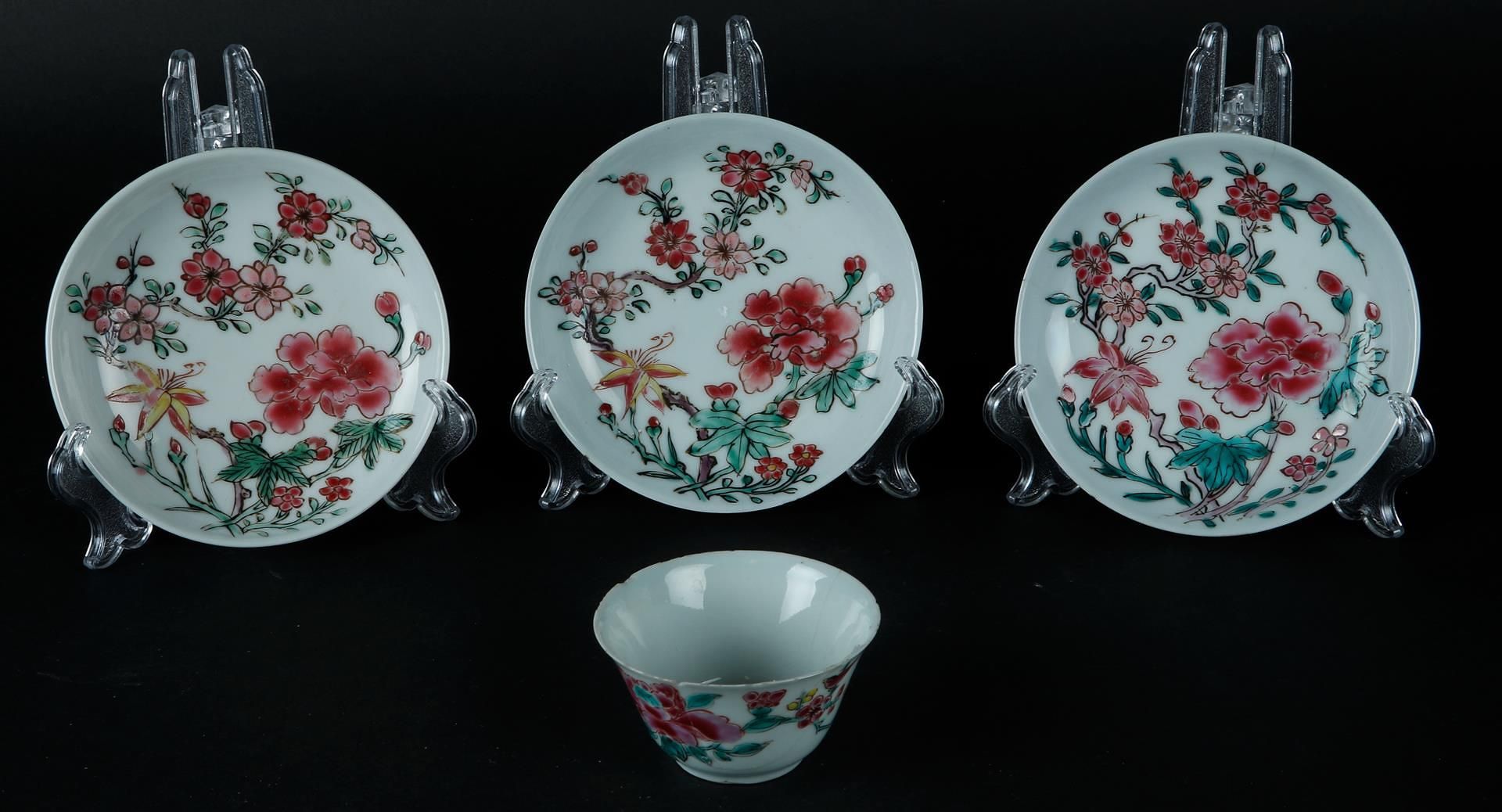 Three porcelain Famille Rose plates and a cup with rich floral decoration. China, Yongzheng.