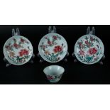 Three porcelain Famille Rose plates and a cup with rich floral decoration. China, Yongzheng.