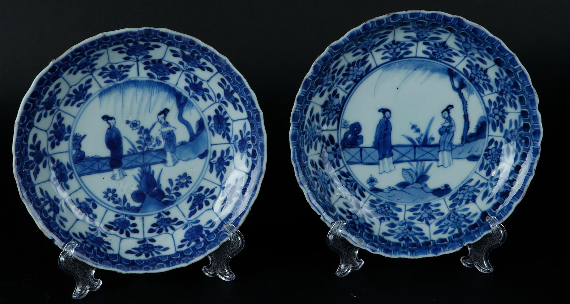 Two porcelain plates with floral outer border decoration, the center with two standing frames with f