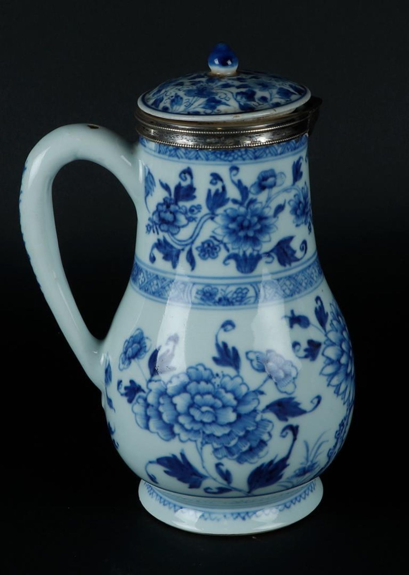 A large porcelain jug with peony decoration, around which rich floral decoration. With silver neck r