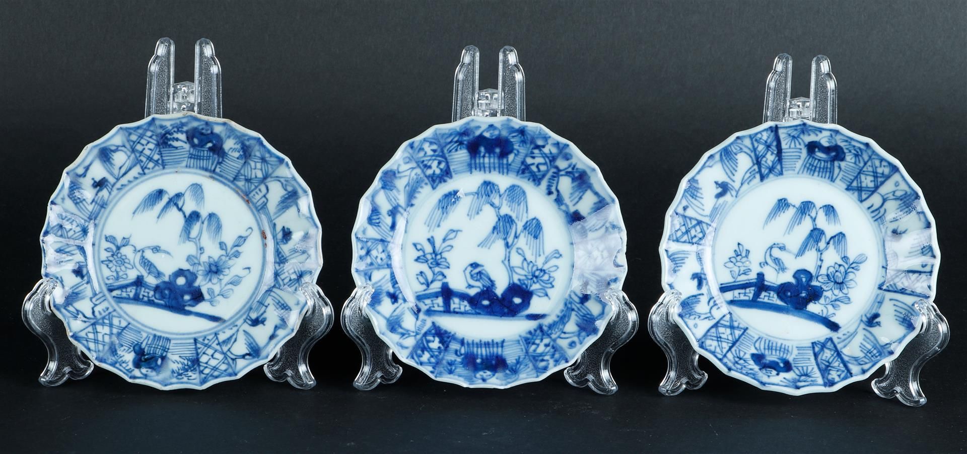 Three porcelain contoured cups and saucers with landscape and willow decor. China, Qianlong.