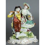 A porcelain group of an elegant couple with flute player, on rococo base. Vollstedt, ca 1900.