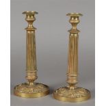 Two gilt copper candlesticks with rosette relief decoration on the foot and fluted stem. France, Cha