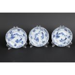 A set of three porcelain plates with landscape decor and floral decor in sections. China, Kangxi.