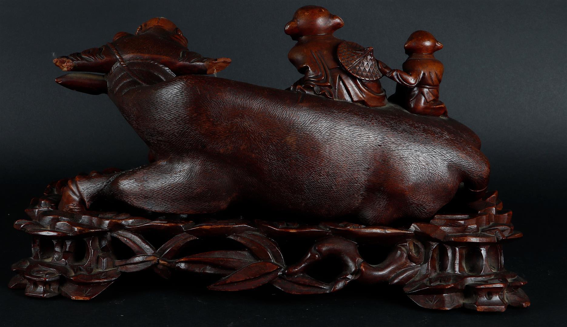 A wooden sculpture of a Chinese boy on a water buffalo, on a wooden base. China, 20th century. - Image 2 of 2