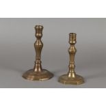 Two bronze candlesticks, one with an 8-sided base, the other with a contoured base. 18th century.