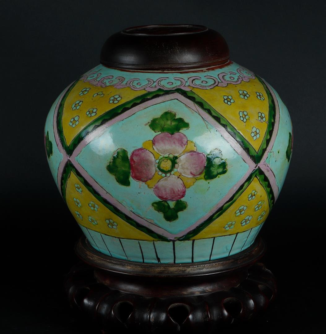 A porcelain storage jar with wooden lid and base. China, 19th century.