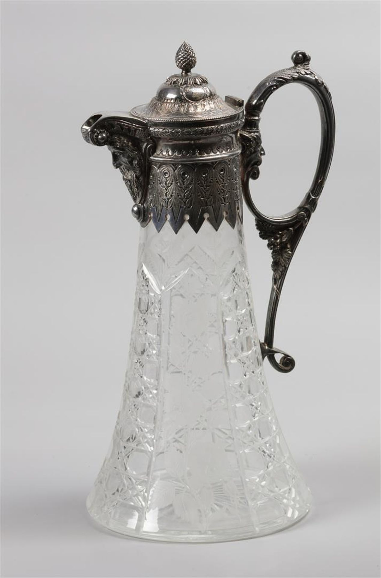 A cut and etched glass wine decanter with a silver Neo-Renaissance frame with a Wildman head on the 