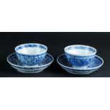 A set of two porcelain cups and saucers with floral decor, marked in the period.