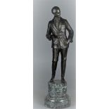 A bronze sculpture depicting a gentleman in evening jacket mounted on a green marble base. 20th cent
