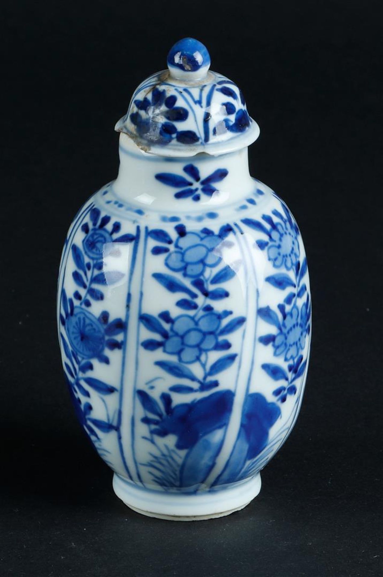 A porcelain lidded vase with sloping compartments with floral decor. China, Kangxi.