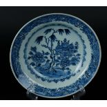 A porcelain deep plate with weeping willow and antiques on a tree stump. China, Qianlong.
