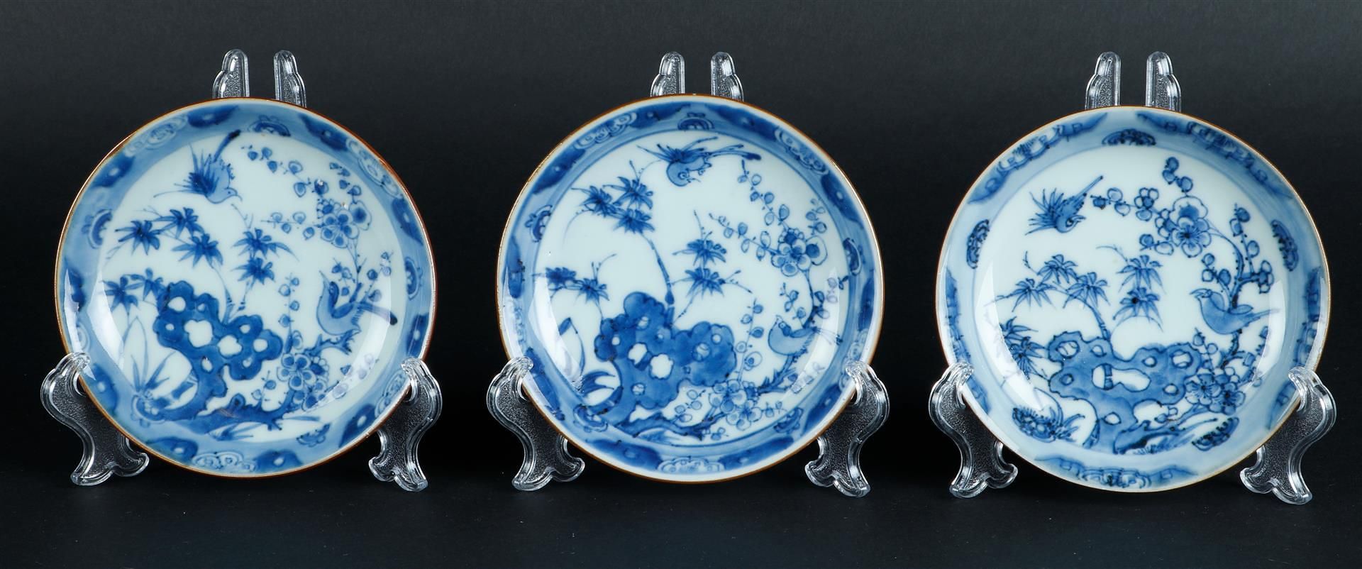 Three porcelain plates with floral decoration on rock with two birds, with clouded outer rim and cap