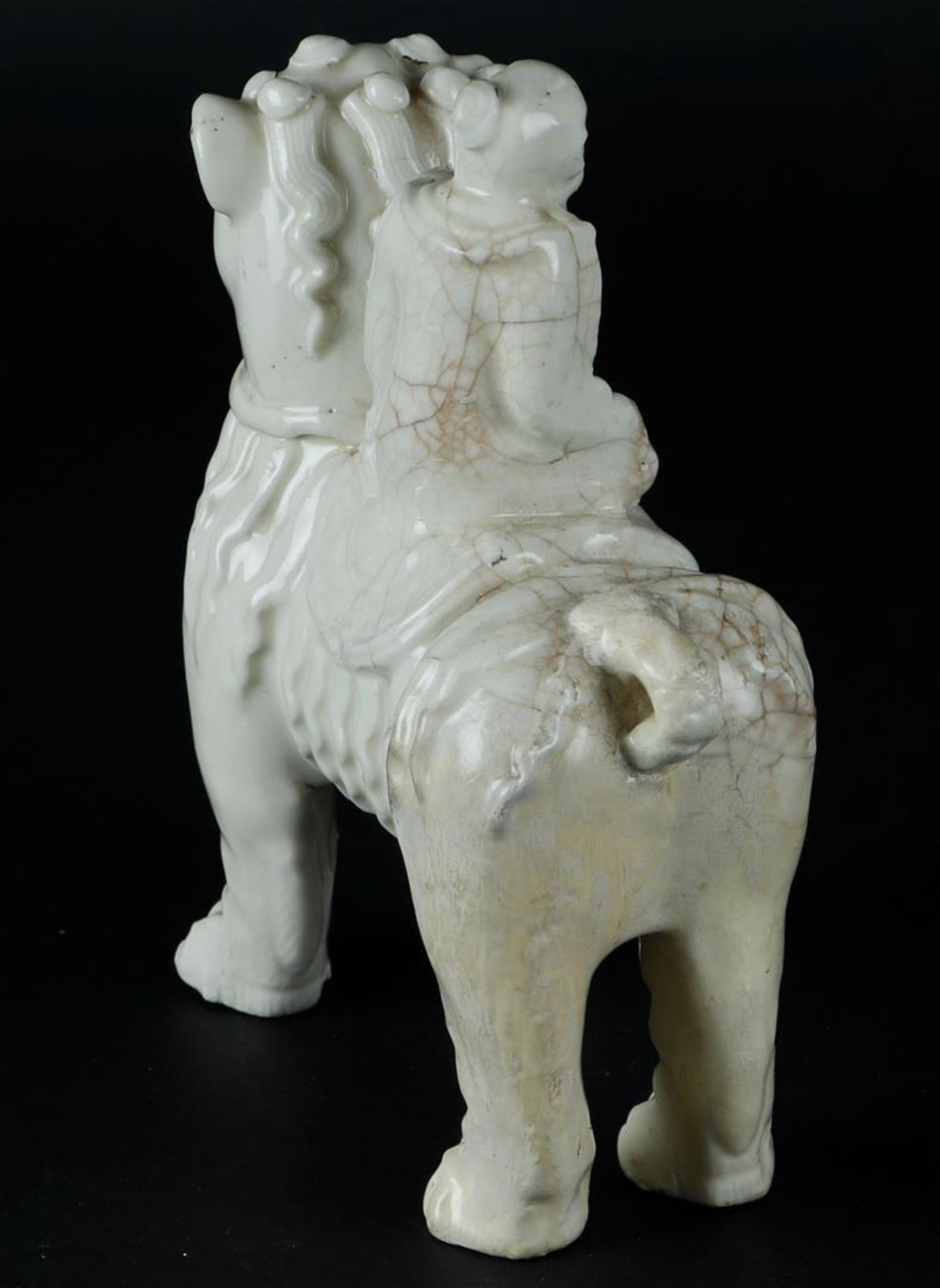 A porcelain blanc de chine foo dog with a figure on it. China, Kangxi. - Image 4 of 6