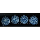 Four porcelain plates with decoration in the center of two seated figures in a landscape. China, Kan