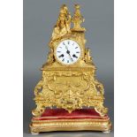 A fire-gilt bronze French mantel clock with a woman receiving a love letter on top. On the medallion