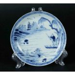 A porcelain plate with a river landscape with a pagoda, with a fisherman in a boat in the foreground