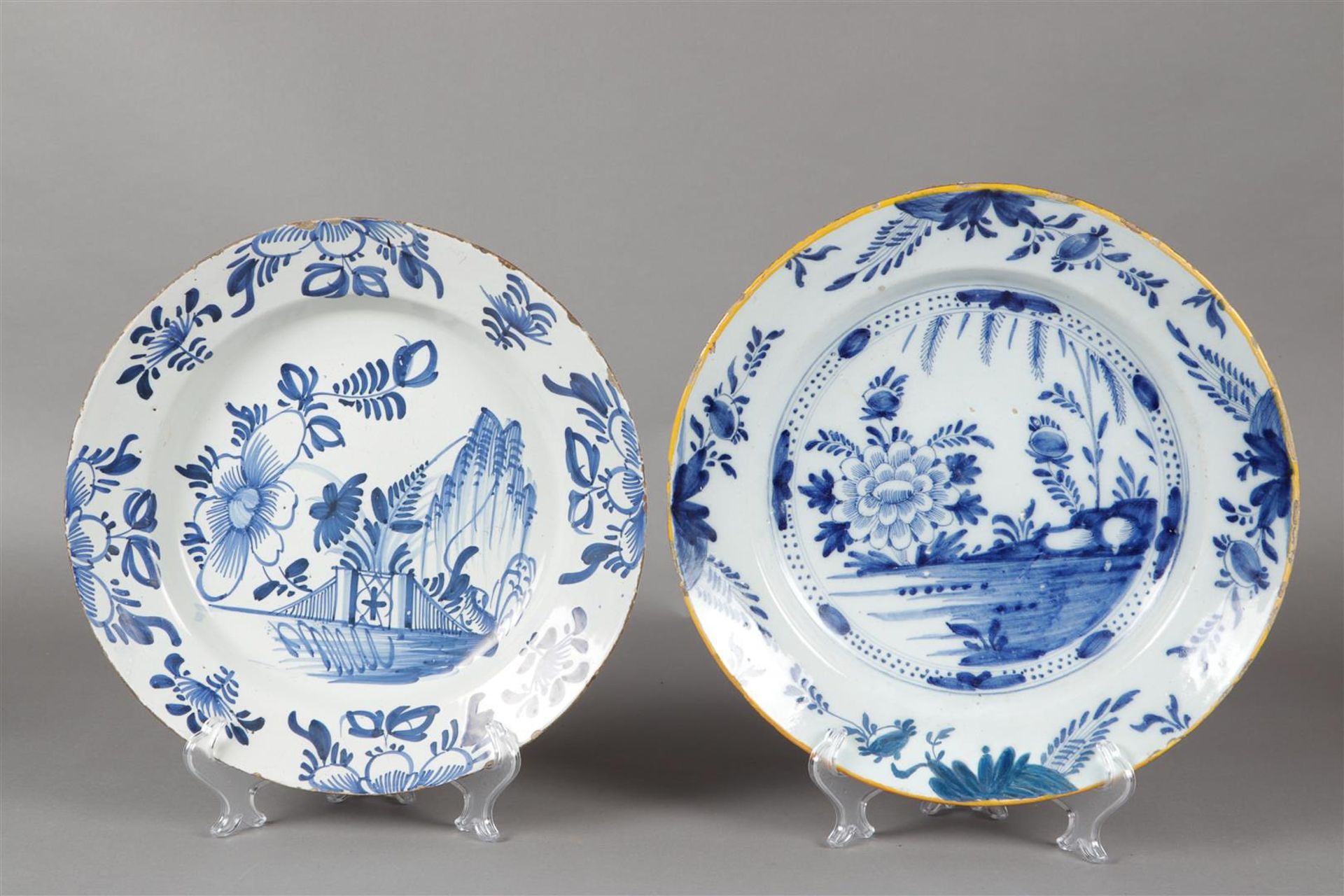 A lot of two floral painted earthenware dishes. Delft, around 1800.